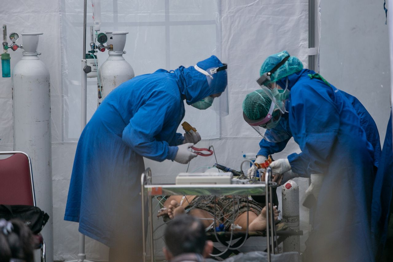 أفراد من الطاقم الطبي يعالجون مريضا مصابا بفيروس كورونا في مستشفى باقليم يوجياكارتا يوم الرابع من يوليو تموز 2021. صورة لرويترز. يحظر استخدام الصورة في إندونيسيا.