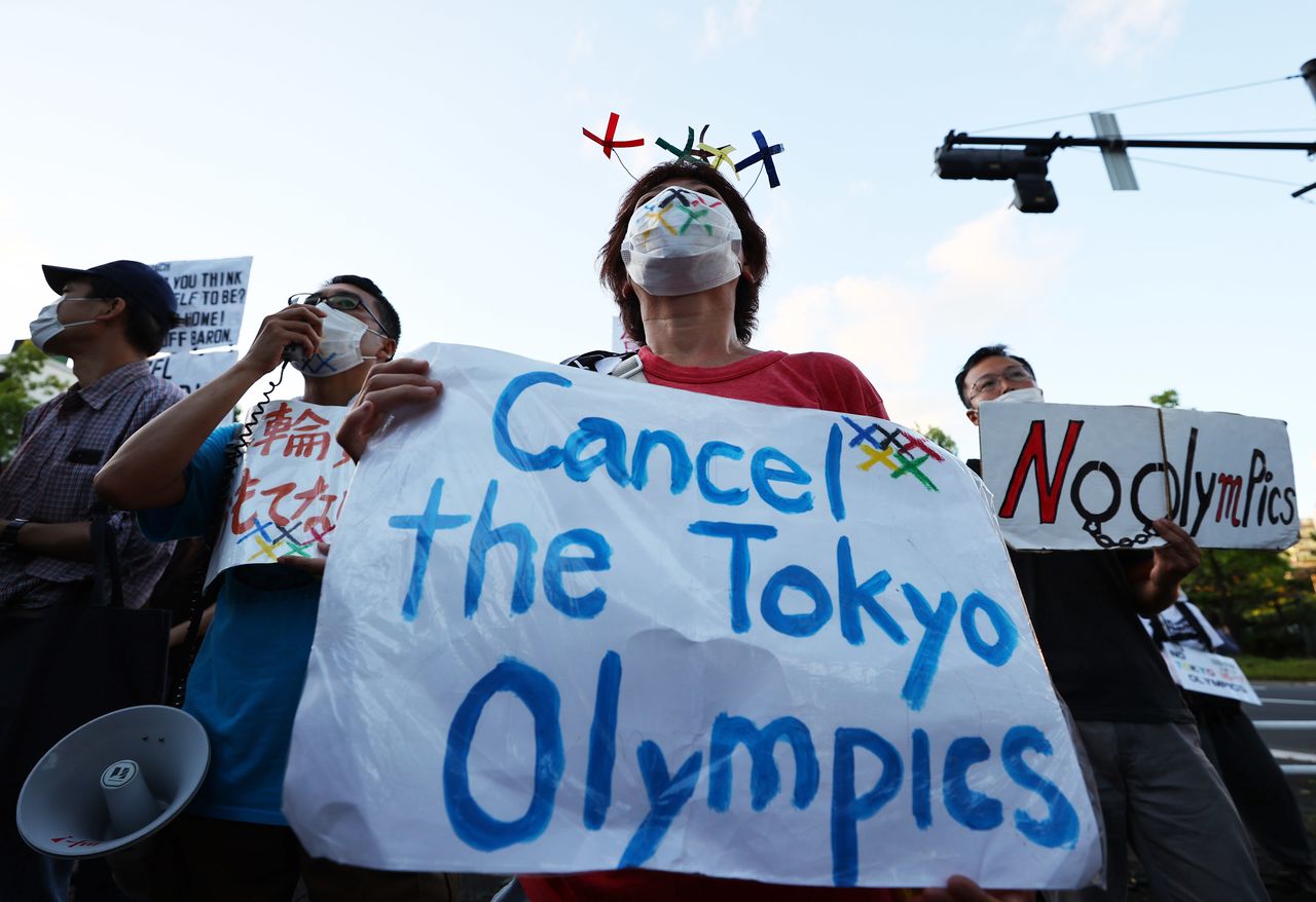 أشخاص يحتجون على دورة الألعاب الأولمبية في طوكيو يوم الأحد. تصوير: كيم كيونج هوون - رويترز