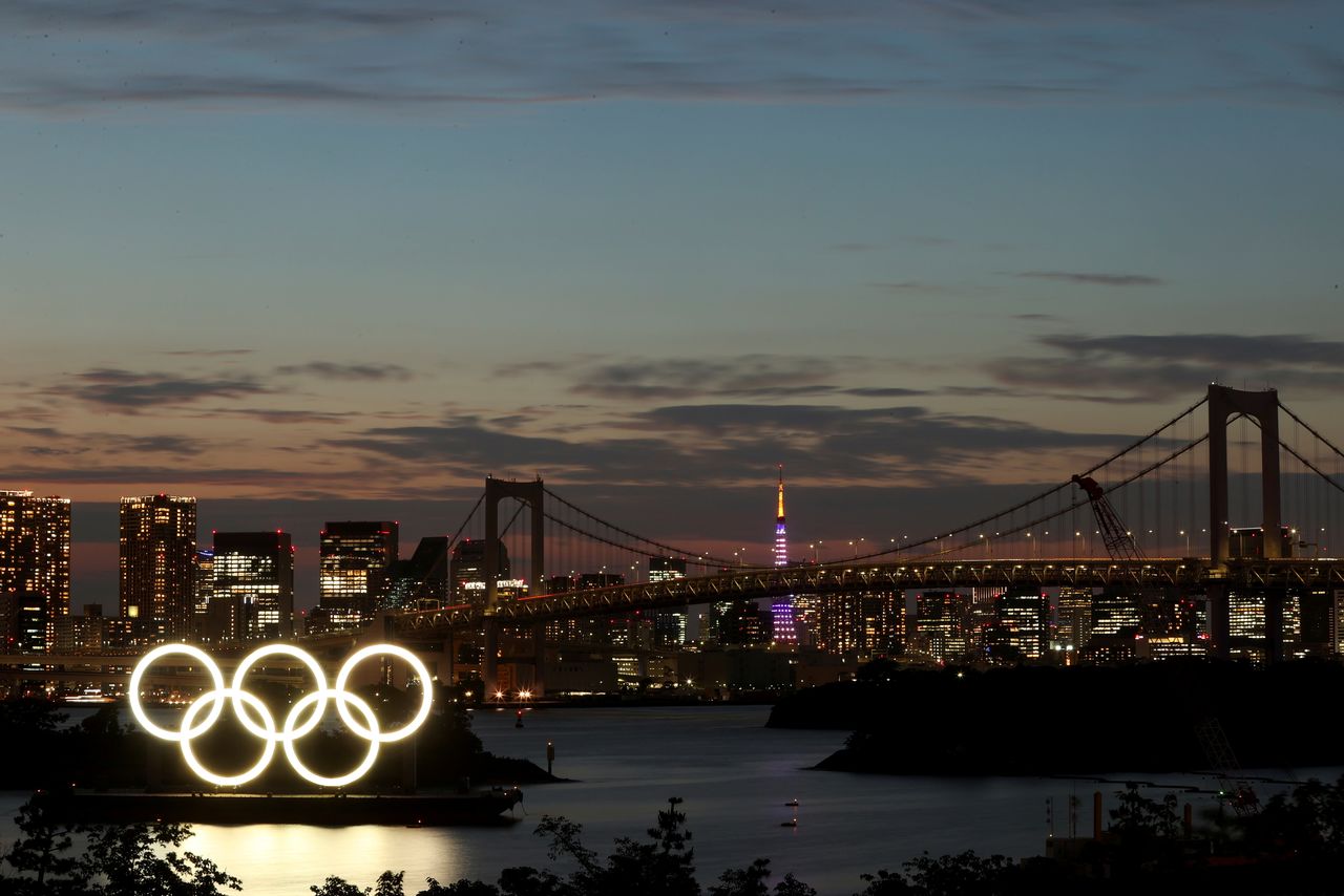منظر عام للحلقات الأولمبية المثبتة على منصة عائمة مع جسر قوس قزح في الخلفية استعدادًا لدورة الألعاب الأولمبية طوكيو 2020 في طوكيو، اليابان في 21 يونيو/ حزيران 2021. باول كوبشينسكي/ رويترز.