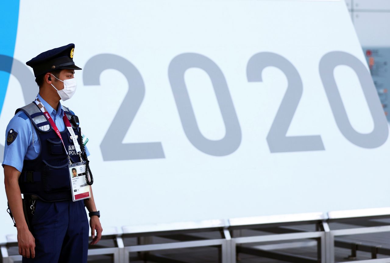 شرطي يضع كمامة يقف حراسة خلال أولمبياد طوكيو 2020 في طوكيو يوم 24 يوليو تموز 2021. تصوير: سيفيو سيبيكو - رويترز
