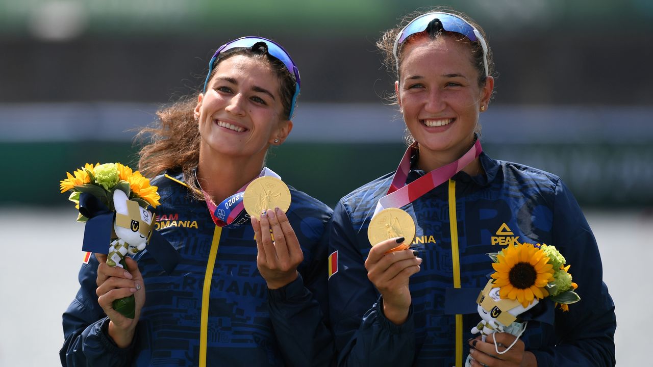 الرومانيتان أنكوتا بودنار وسيمونا راديس تحتفلان بالفوز بذهبية القارب الزوجي بمجدافين في منافسات التجديف بأولمبياد طوكيو يوم الأربعاء. تصوير: رويترز.