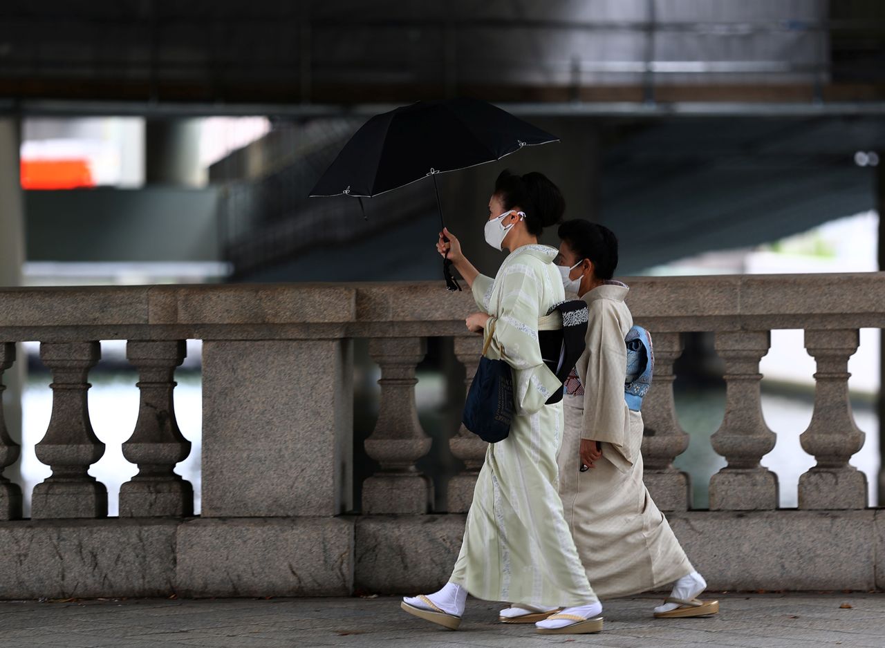 امرأتان تضعان كمامتين للوقاية من فيروس كورونا في طوكيو يوم الخميس. تصوير: كيم كيونج-هوون - رويترز.