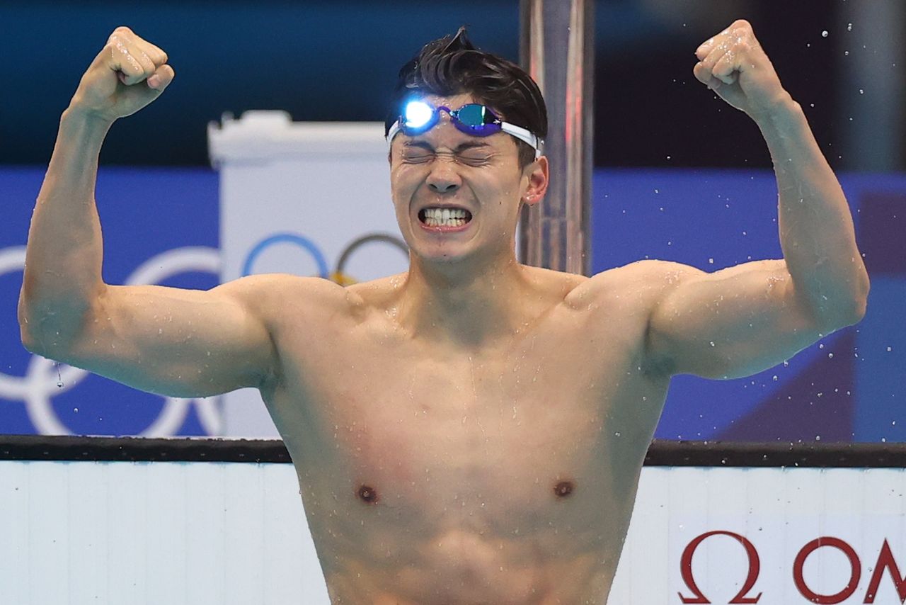 السباح الصيني وانغ شون يحتفل بفوزه بذهبية سباق 200 متر فردي متنوع في أولمبياد طوكيو يوم الجمعة. تصوير: ماركو ديوريكا - رويترز.