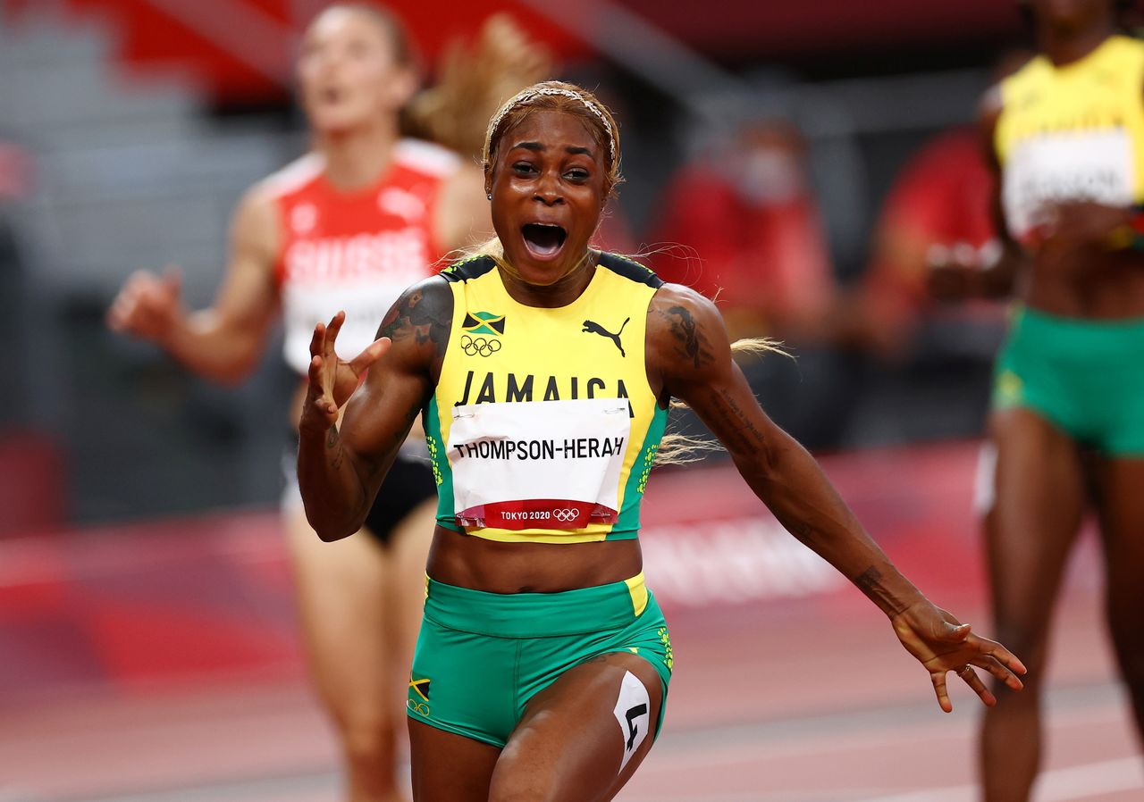 العداءة الجاميكية إيلين طومسون-هيرا تحتفل بفوزها بذهبية 100 متر للسيدات في أولمبياد طوكيو يوم السبت. تصوير: كاي فافنباخ - رويترز.