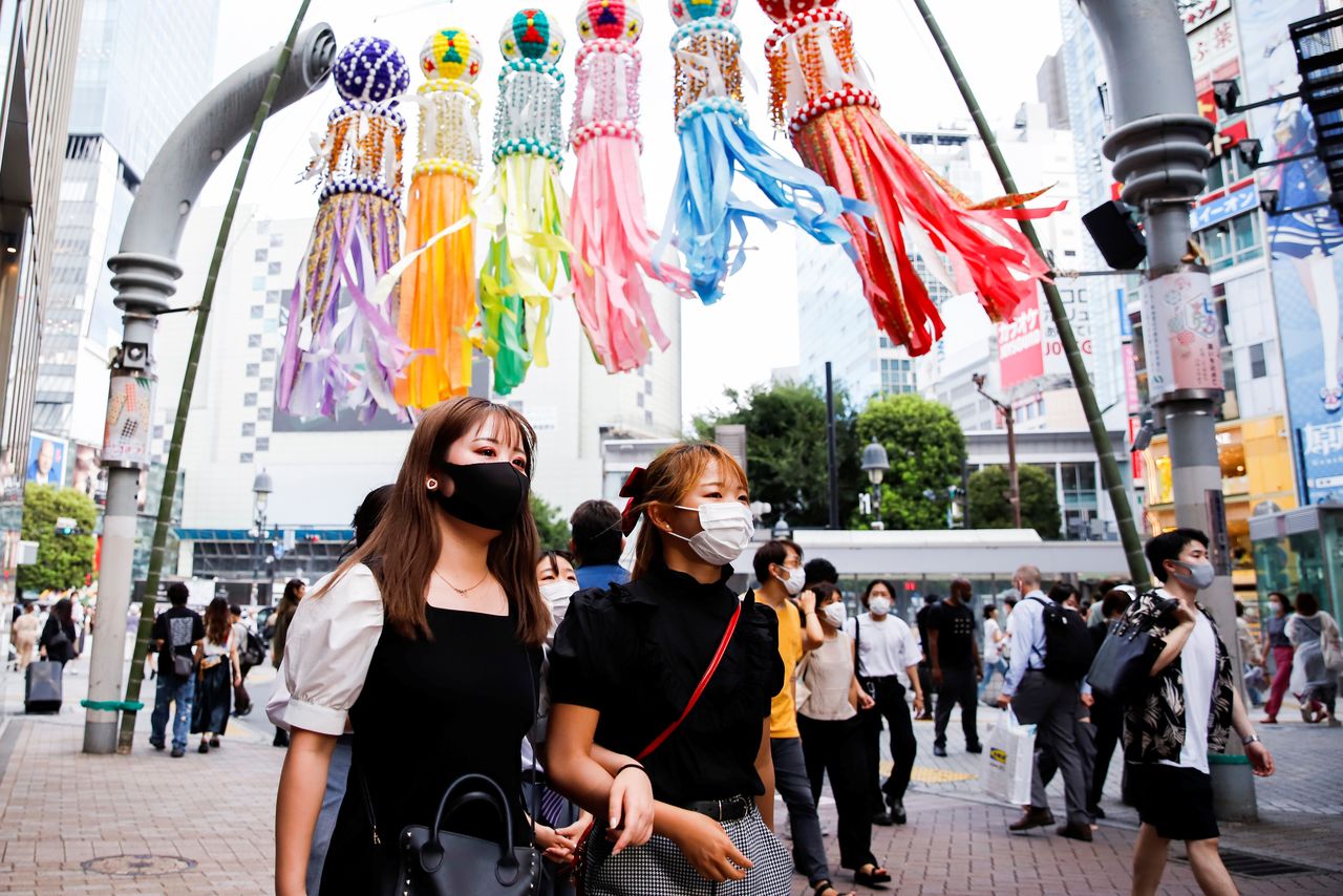 أشخاص يضعون كمامات للوقاية من فيروس كورونا في طوكيو يوم 29 يوليو تموز 2021. صورة لرويترز.