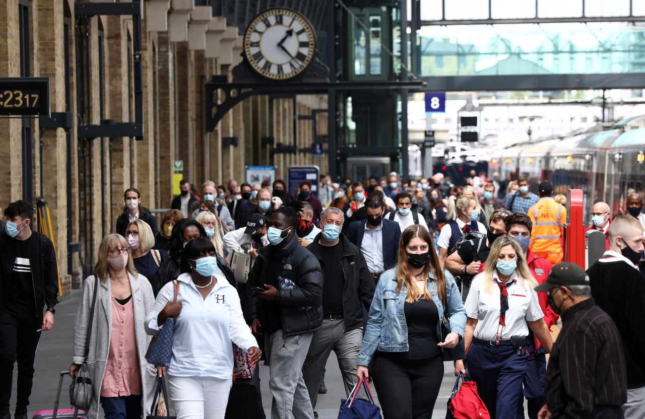 أفراد يضعون كمامات للوقاية من فيروس كورونا في لندن يوم 12 يوليو تموز 2021. تصوير: هنري نيكولز - رويترز.