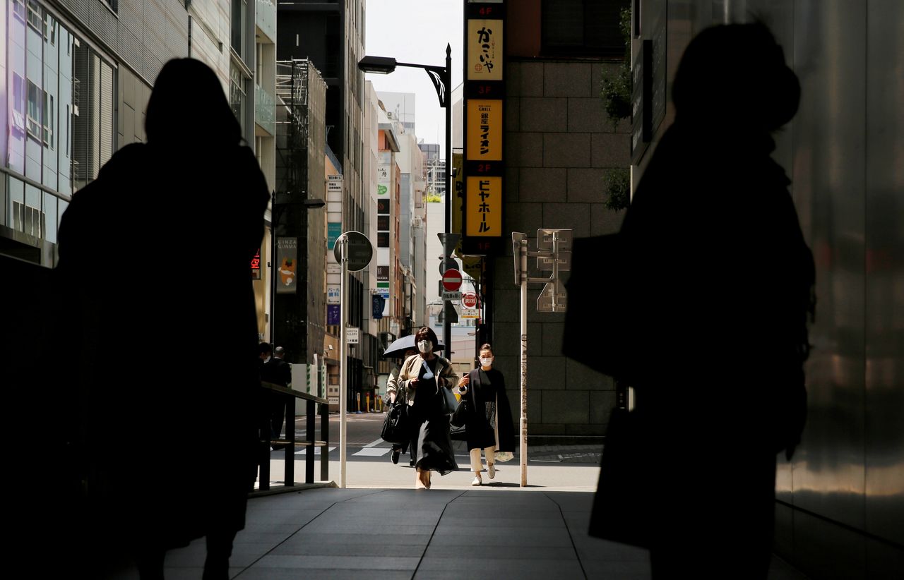 أشخاص يضعون كمامات للوقاية من فيروس كورونا في طوكيو يوم 25 أبريل نيسان 2021. تصوير: كيم كيونج-هوون - رويترز.