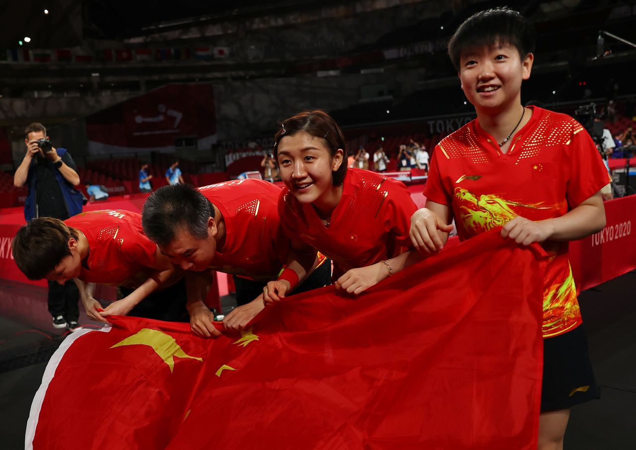 الفريق الصيني المؤلف من تشين مينغ وسون ينغشا ووانغ مانيو يحتفل بالفوز بذهبية فرق السيدات في تنس الطاولة في ألعاب طوكيو يوم الخميس. صورة لرويترز.