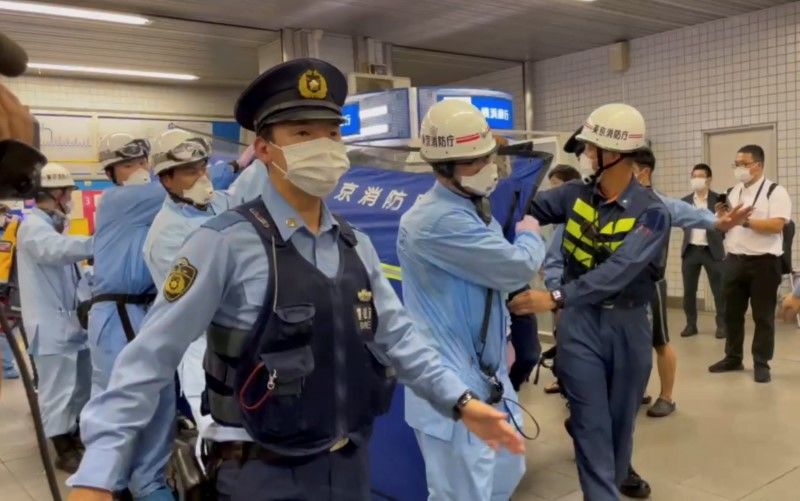 عمال الإنقاذ التابعون للشرطة يحملون شخصًا عبر محطة قطار بعد هجوم بسكين على قطار في طوكيو، اليابان، 6 أغسطس/ آب 2021 في هذه الصورة الثابتة المأخوذة من مقطع فيديو حصلت عليه رويترز.