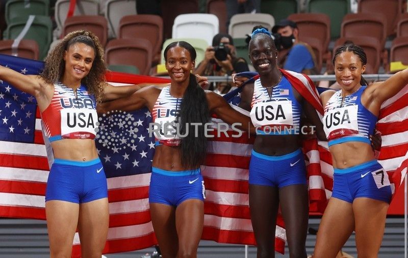 أفراد الفريق الأمريكي في سباق أربعة في 400 متر تتابع للسيدات يحتفلن بالفوز بذهبية السباق في أولمبياد طوكيو يوم السبت. تصوير: كاي فافنباخ - رويترز.