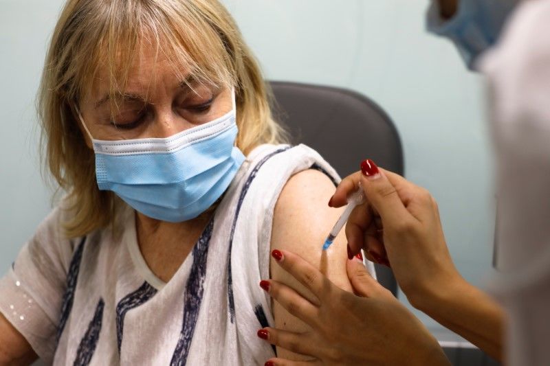 امرأة تحصل على جرعة ثالثة من تطعيم ضد كوفيد-19 في تل ابيب يوم أول أغسطس اب 2021. تصوير: نير إلياس - رويترز.