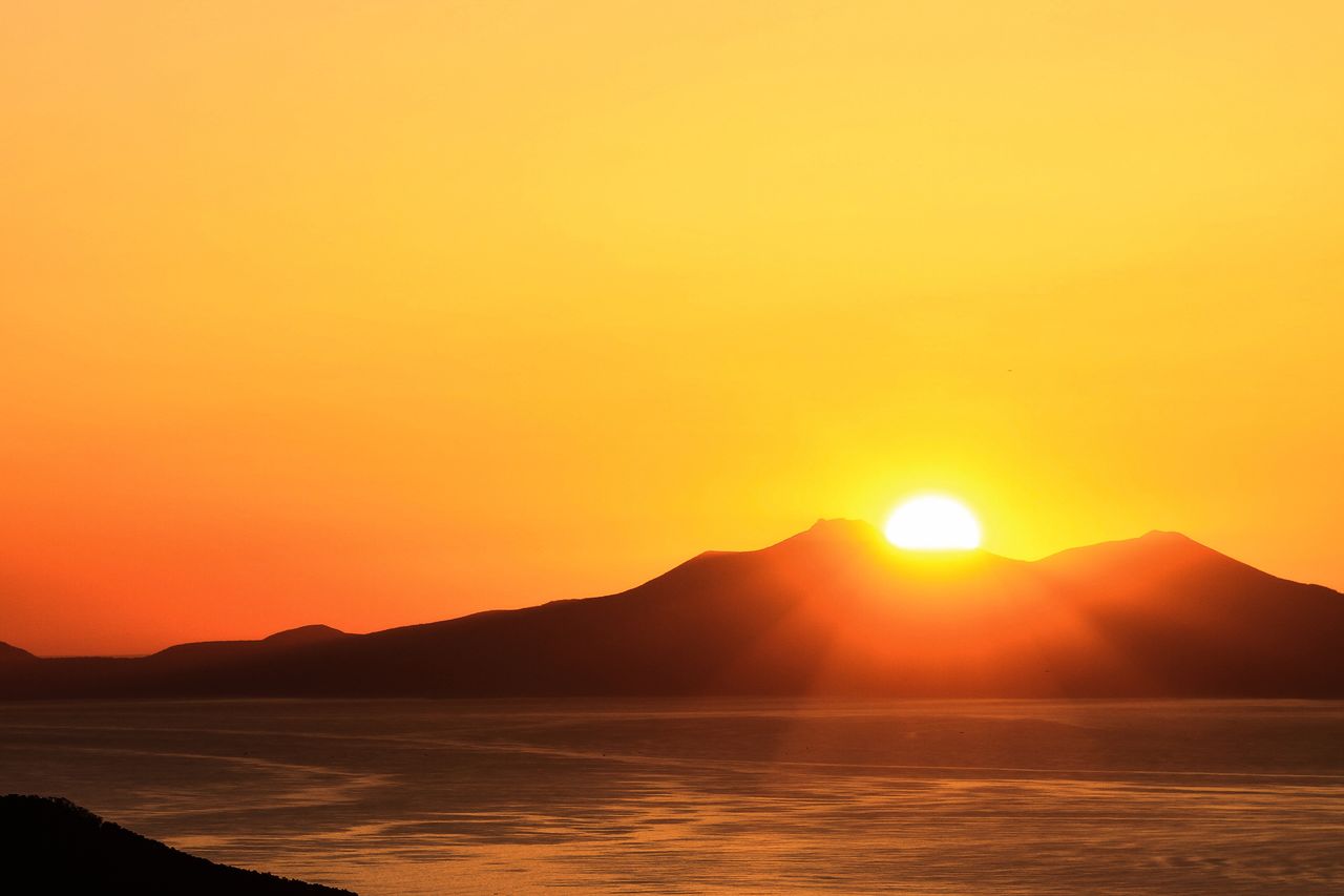 从国后岛背后冉冉升起的朝阳　　照片提供：知床斜里町观光协会