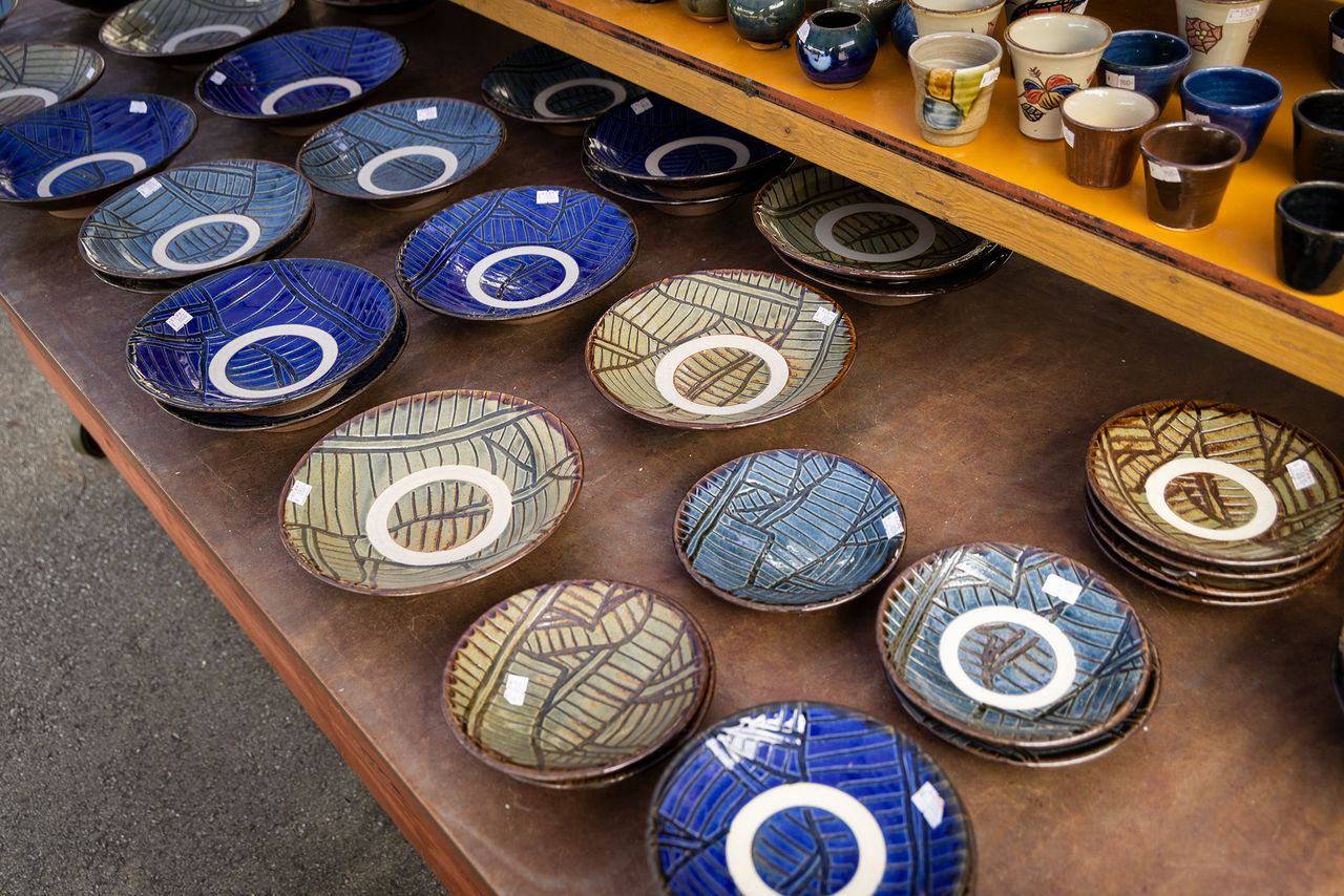 盘子表面的白圈叫“蛇目”，是冲绳陶器的一大特色。盘子摞起来烧制时，要先去除放在上面的盘子底座的釉药，这为盘子的花纹增添了异彩