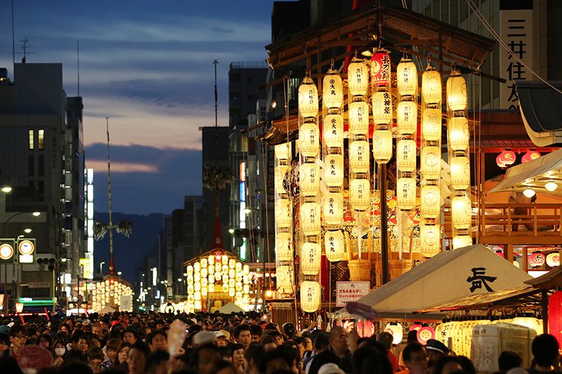 7月16日，正在举办宵山活动的“四条通”街道。驹形灯笼（日本象棋中的棋子称为“驹”，因挂起的一片灯笼其外形与“驹”相似而得名——译注）照亮傍晚时分的京都。海外游客随处可见