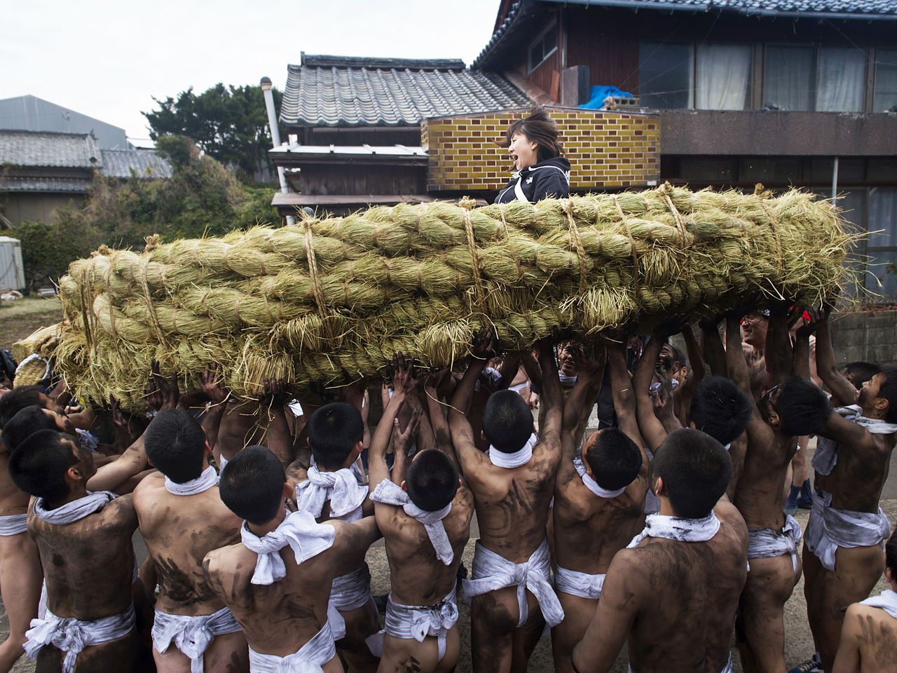 男人们抬起载着女子的大草鞋在村子里游行