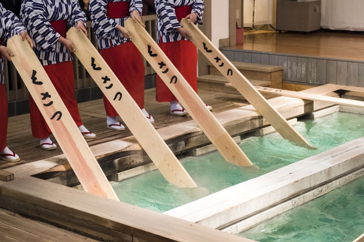 草津温泉最具特色之处是所谓的“汤揉”仪式，即女性表演者用木桨有节奏地搅动刚从地下抽出的温泉水，直至其降至可以用于洗浴的温度（© Pixta）