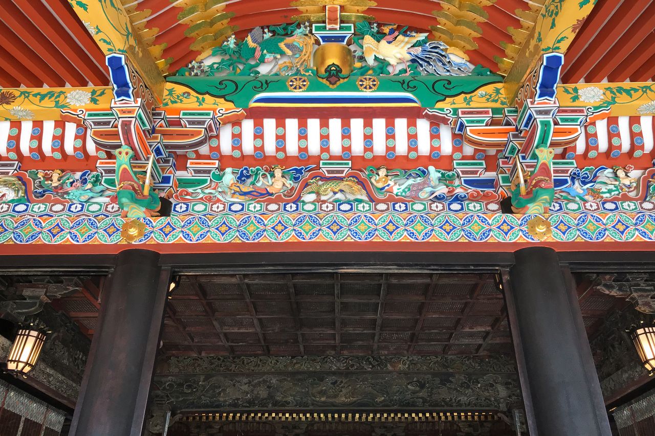 拜殿正面的三角形屋顶装饰之下，雕刻着色泽鲜艳的花纹（提供：大崎八幡宫）
