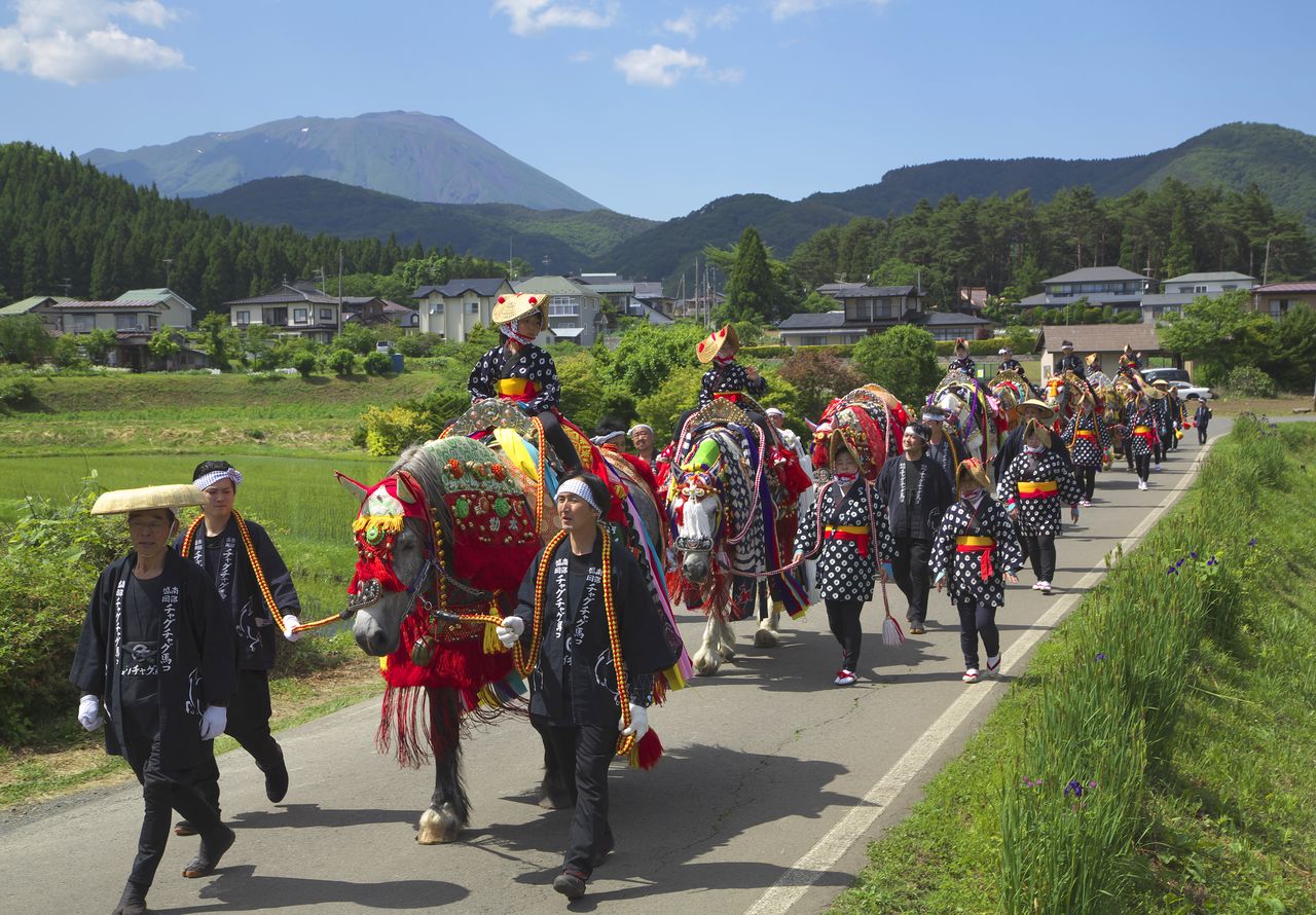 约100匹马和马主们一起列队前行