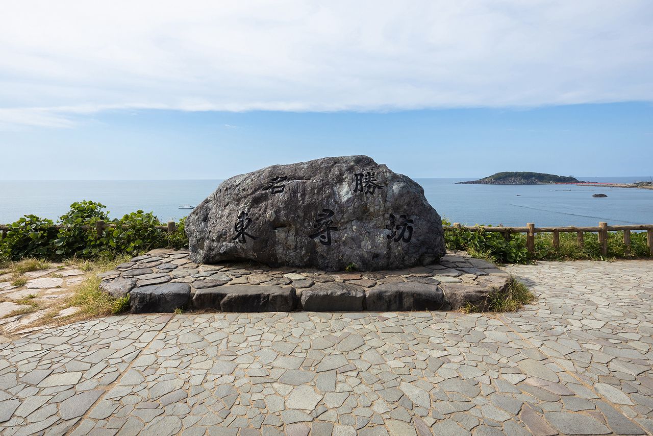 “名胜 东寻坊”石碑。右上方漂浮的是神之岛“雄岛”