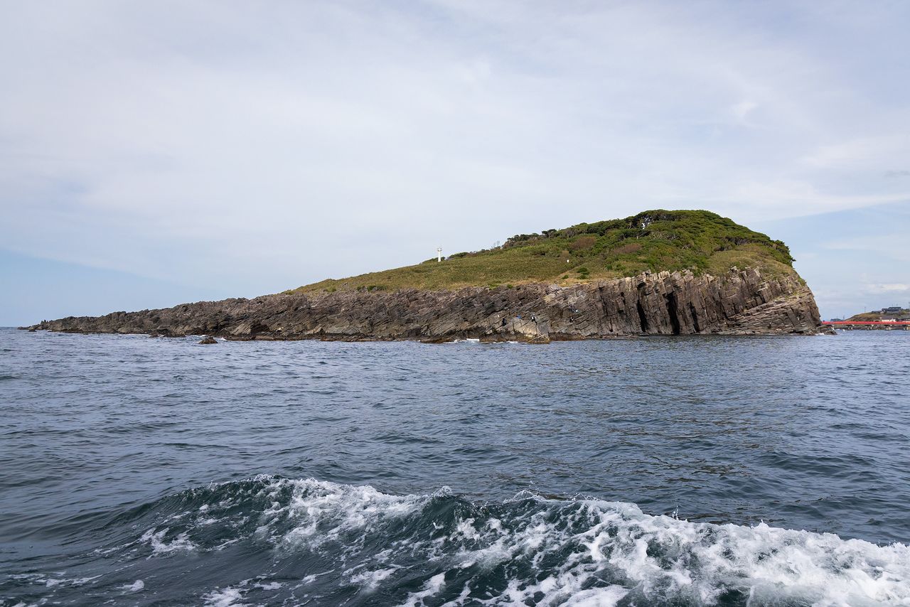 从船上眺望雄岛全景。岩石区左半边是波形岩。最右端的朱红色的雄岛桥,还可以步行穿过 在“蜂巢岩”的崖壁上方,可以看到大凑神社的红色鸟居