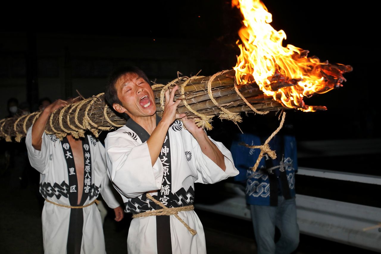 扛着巨大的火把上神社