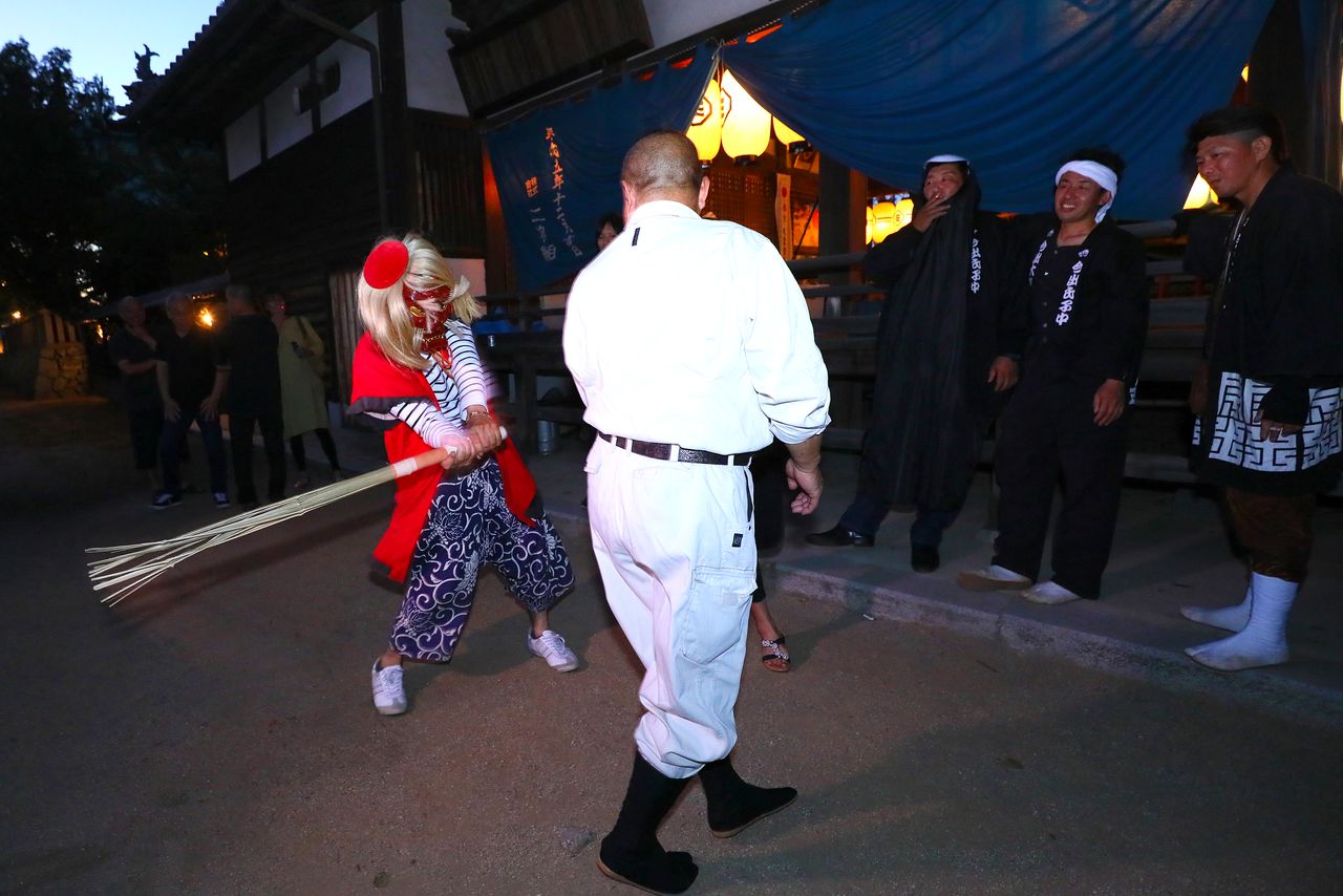 神舆游街时,会有戴着鬼面的精灵“Daiba”现身,用竹棍敲打众人,赐福众人无病无灾