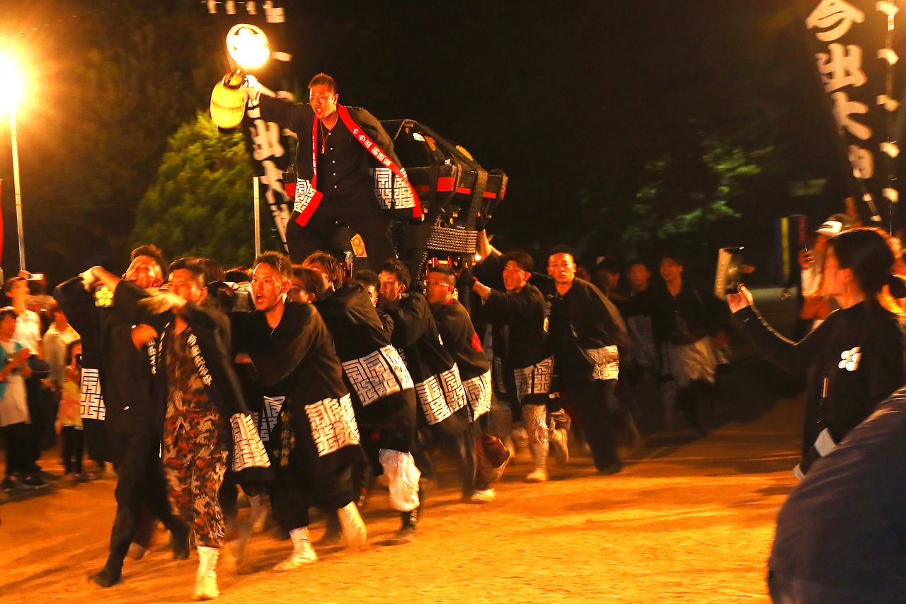 “老爸加油——!”孩子在身后大声助威,青年组扛着神舆向前冲