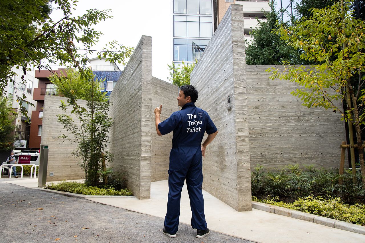惠比寿公园厕所前，身着清洁工制服的笹川理事。他说：“制服不仅帅气，弹性好还方便活动。希望清洁工能为自己的工作感到骄傲”