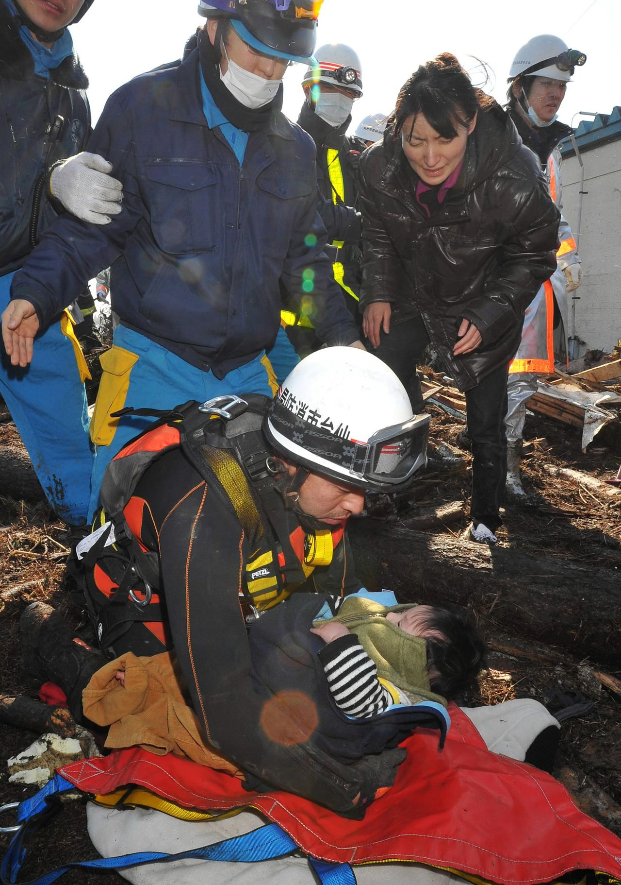 3月12日 上午9时30分 宫城县仙台市若林区 消防直升机的救助队员救出的婴儿和不胜感激的母亲（右）