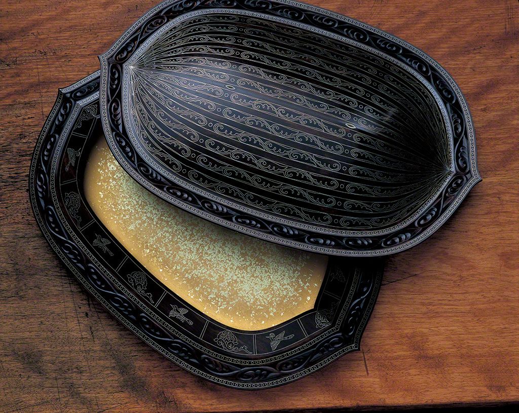“莲瓣唐草文透嵌庄合子”,1999年。打开盒盖,映入眼帘的是金箔艳丽而庄严的世界。在黑柿木表面“嵌庄”了锡的作品。