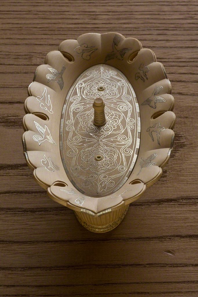 “黄杨锡嵌庄花形香合”,2009年。黄杨木表面“嵌庄”了锡。