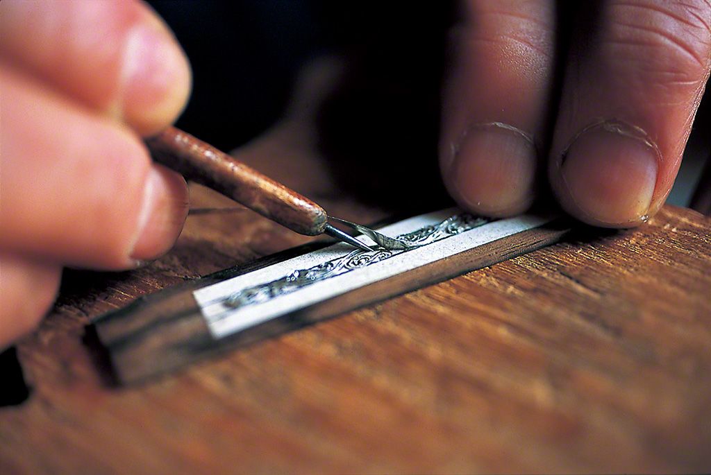 将锡镶嵌进木片图样中。厚度只有零点数毫米,这是对精度要求极高的作业。将这个木片镶入木胎,表现出大坂独特的世界观。