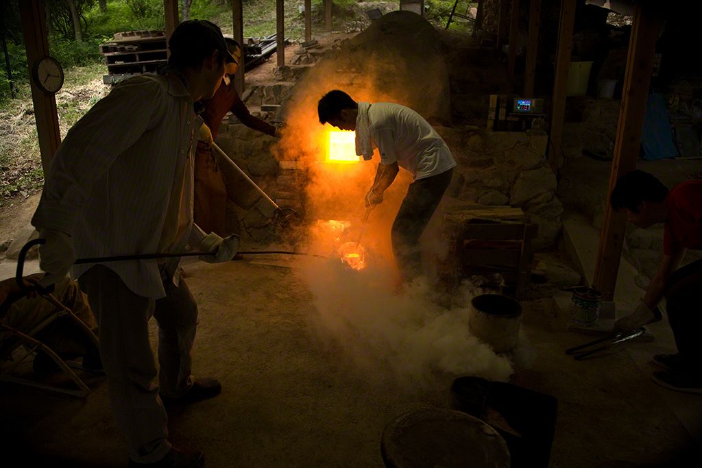 在烧窑时，取出炉口附近的作品进行检查