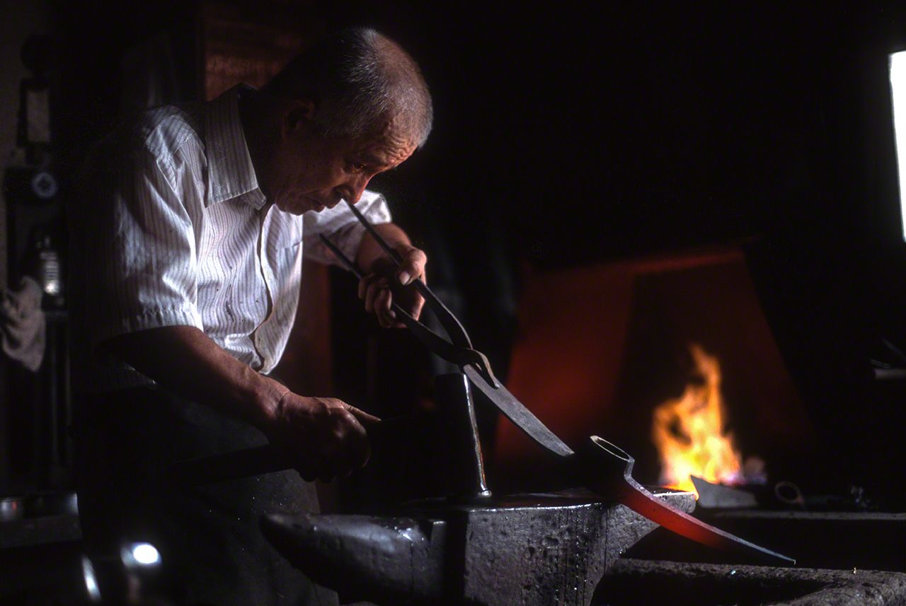 京都府绫部市的锻冶重铁铺。匠人正在修复用于挖掘土石的工具洋镐，使镐头恢复锋利