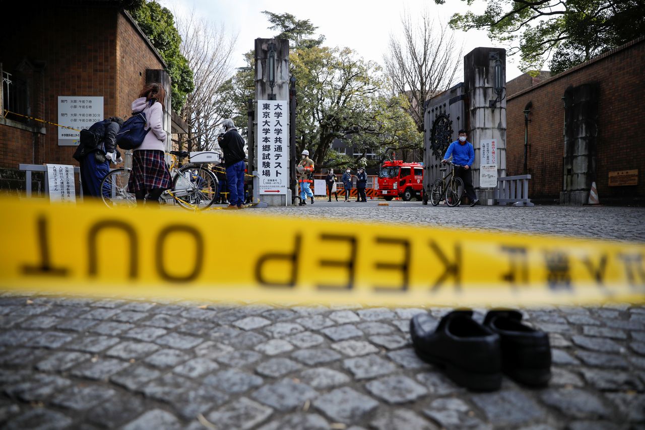 刑侦人员在发生伤人事件的东京大学校门前勘查现场（2022年1月15日，路透社）