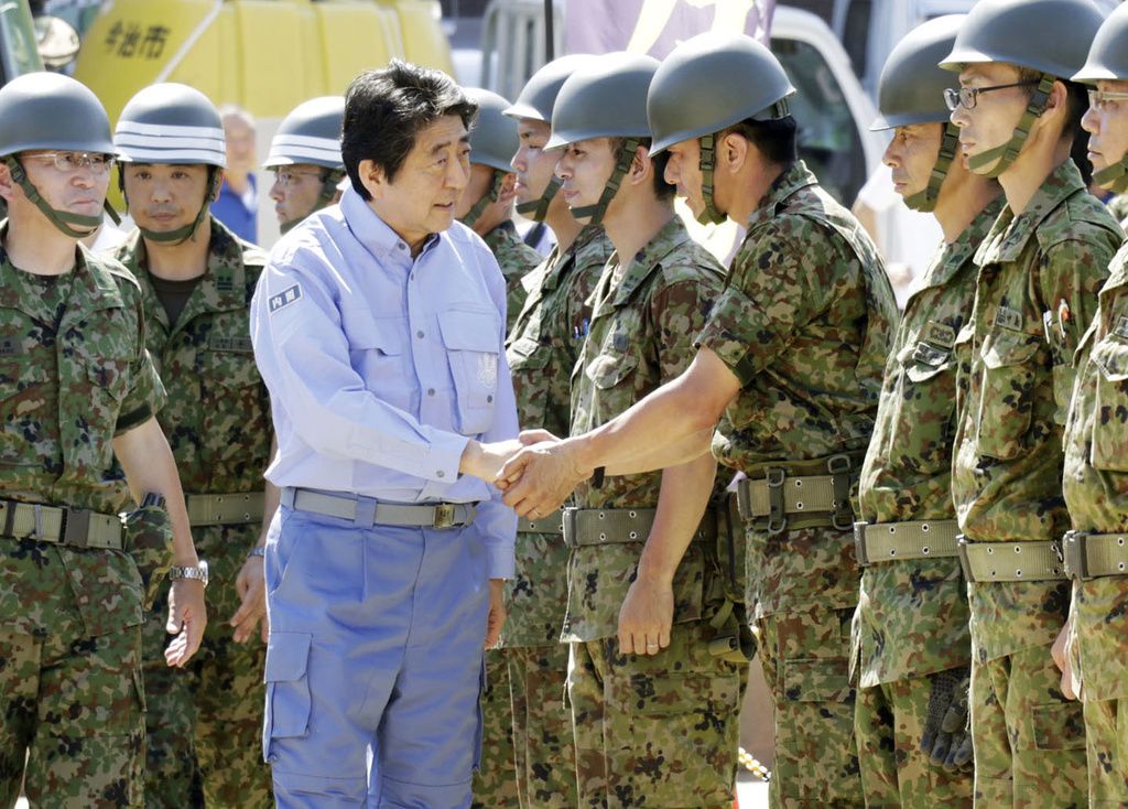 2018年7月13日，安倍首相慰问激励在爱媛县宇和岛市救助西日本暴雨受灾群众的自卫队员（共同社）