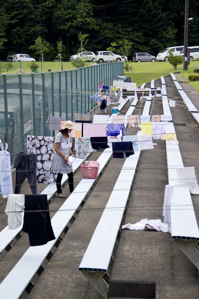 在网球场旁边,清洗的衣物随风飘舞。