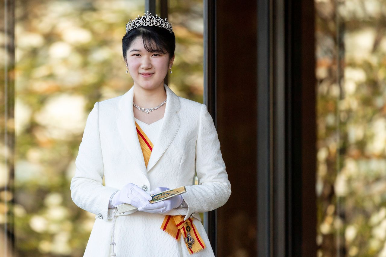 德仁天皇和皇后的长女爱子公主佩戴头冠和勋章，身着正装礼服，出席成人礼活动 （2021年12月5日于皇居 宫殿西门，记者团代表摄影，路透社）