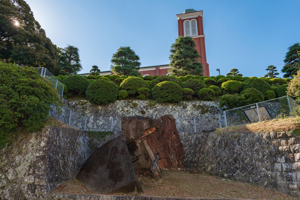 浦上天主堂旧钟楼。天主堂正面的两座塔式钟楼也被原子弹破坏,北侧的钟楼滑落到了流经天主堂边崖壁的小河里。一度被埋入石墙之中,后于1971年作为原子弹轰炸遗迹而被挖掘出来。由钢筋混凝土建造,直径5.5米,推测重约50吨(图片:PIXTA)