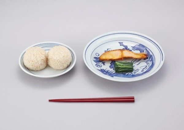 照片为明治22年（1889年）日本最初的学校供餐，菜品为饭团、咸鲑鱼和咸菜
