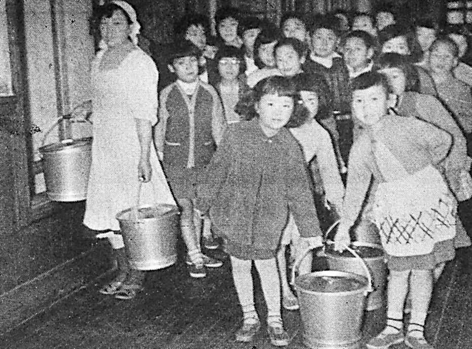 负责将装在桶里的午餐从厨房运到教室的孩子们（1960年前后，北海道旭川市立青云小学）