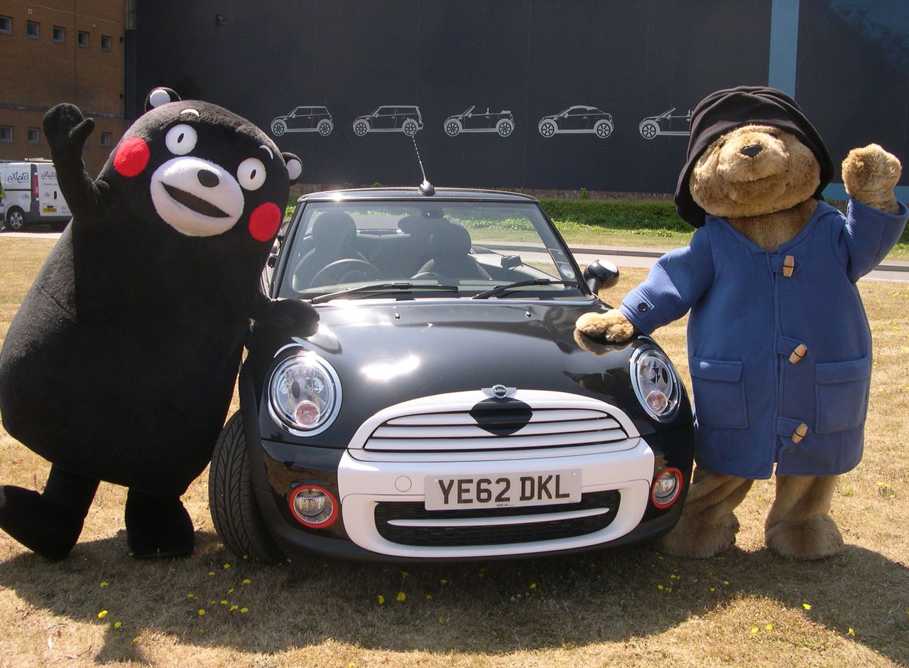 与帕丁顿熊（右）一起展示BMW特别型号车（熊本熊MINI）的熊本熊（图片：时事社，摄于2013年7月11日英国牛津）
