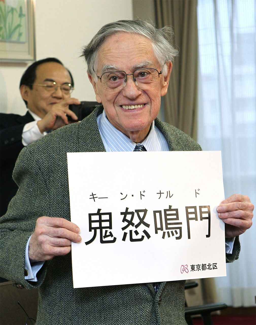 2012年3月8日，取得日本国籍后，金举行新闻发布会，公布了自己的汉字名。后方拿着相机拍照的是他的义子诚己（摄于东京北区政府）（时事社）