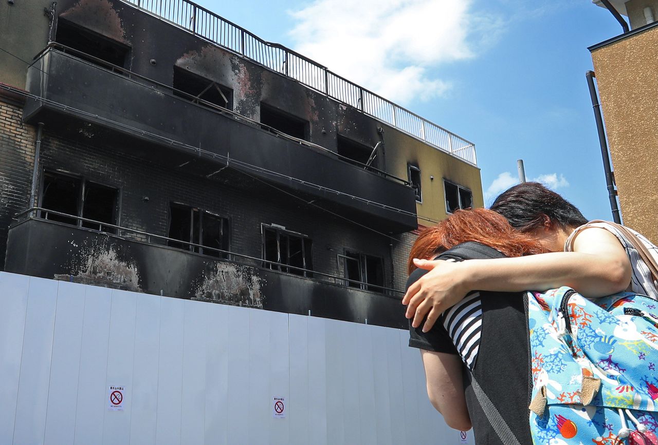 两名女性在遭到纵火烧毁的“京都动漫”楼前潸然泪下，2019年7月25日，京都市伏见区（时事社）