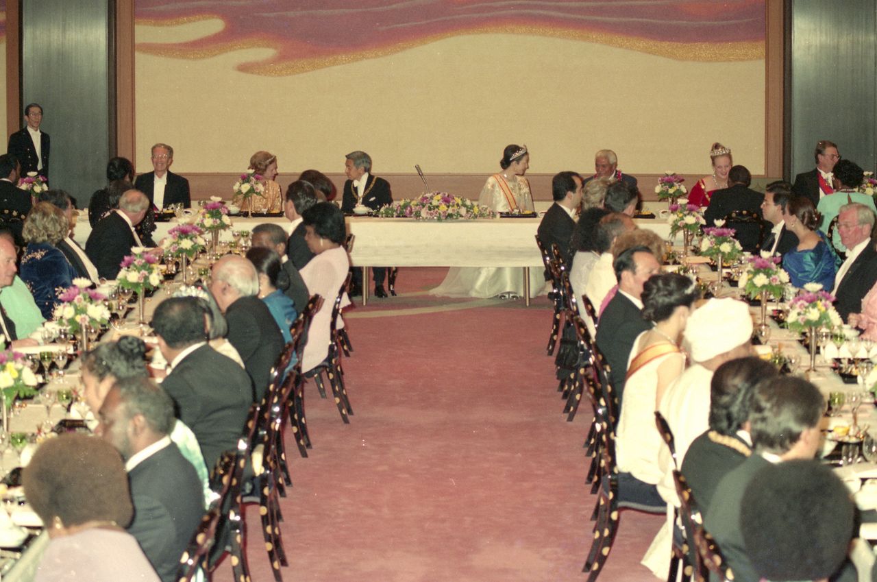 天皇和皇后（现在的上皇夫妇）在平成时代的“飨宴之仪”中与嘉宾欢谈，1990年11月12日，皇居宫殿“丰明殿”（每日新闻社／Aflo）