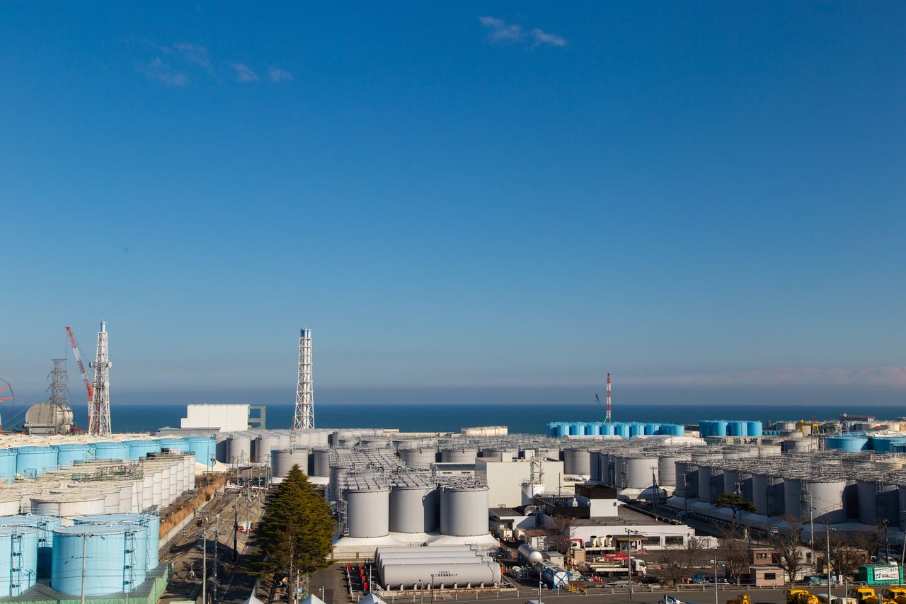 福岛第一核电站现在的外景。近处的水槽内存放着经过净化处理的污水。远处是风平浪静的大海