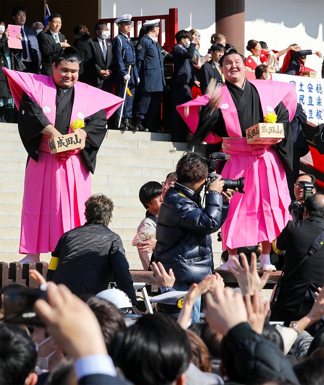 大相扑力士白鹏（右）和高安在成田山新胜寺的“节分会”上撒豆子驱鬼邪（2020年2月3日，千叶县成田市，时事社）