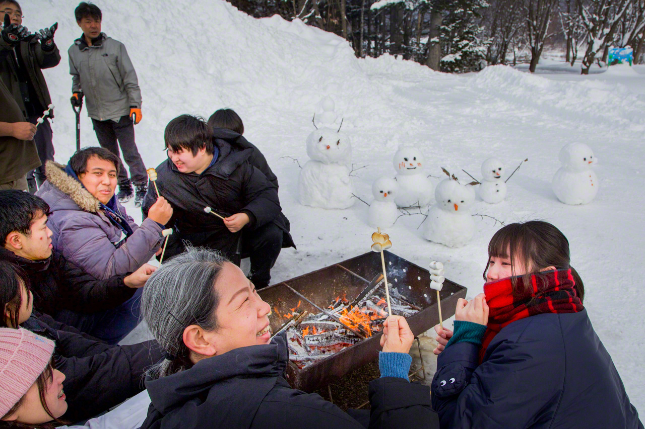 东南亚留学生愉快地堆雪人、烤棉花糖