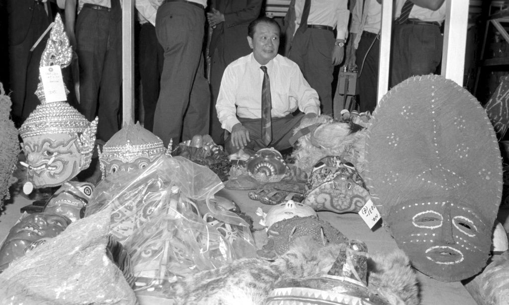 1970年大阪世博会布展前夕,冈本太郎查看从世界各地收集的面具和生活器具(图片:共同社,1969年9月4日)