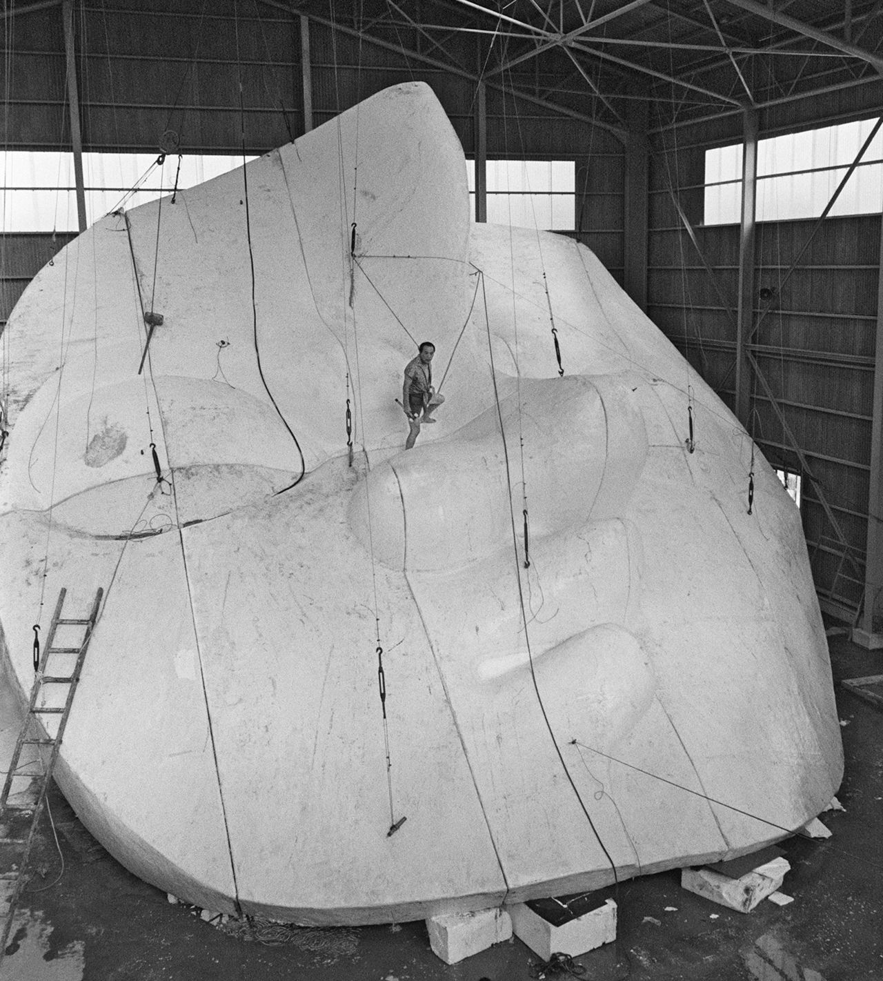 “太阳之塔”正面安装的“太阳之面”,冈本太郎正在中央区域做收尾处理工作。从此图可以看出这一结构部件之巨大(图片:时事社)